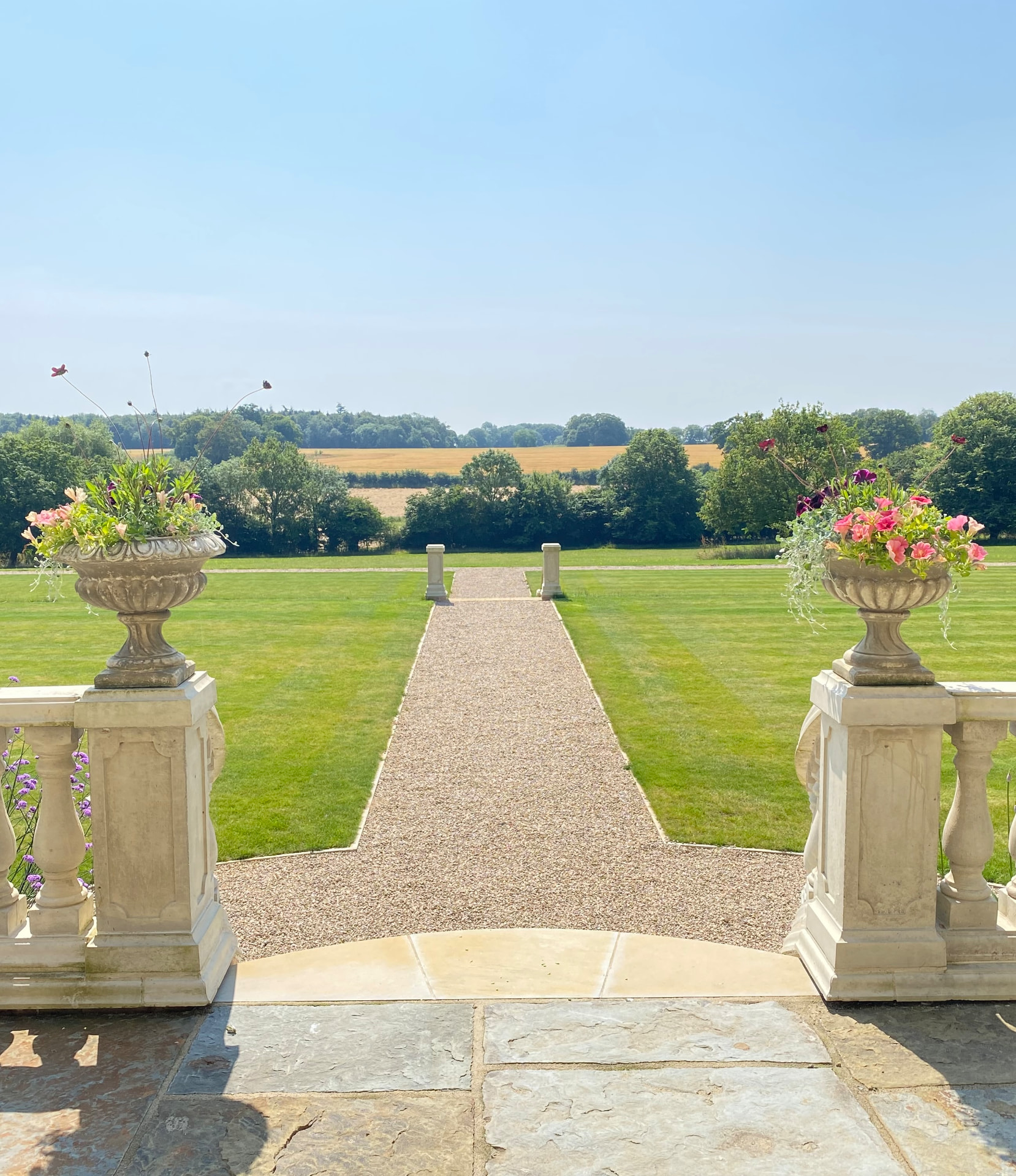 Stone terrace urns framing a long view across the Suffolk landscape