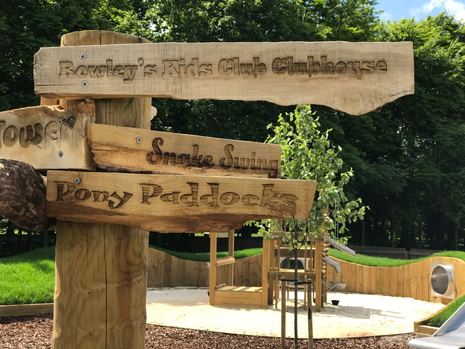 Bespoke carved timber signpost within the Family Enclosure playground