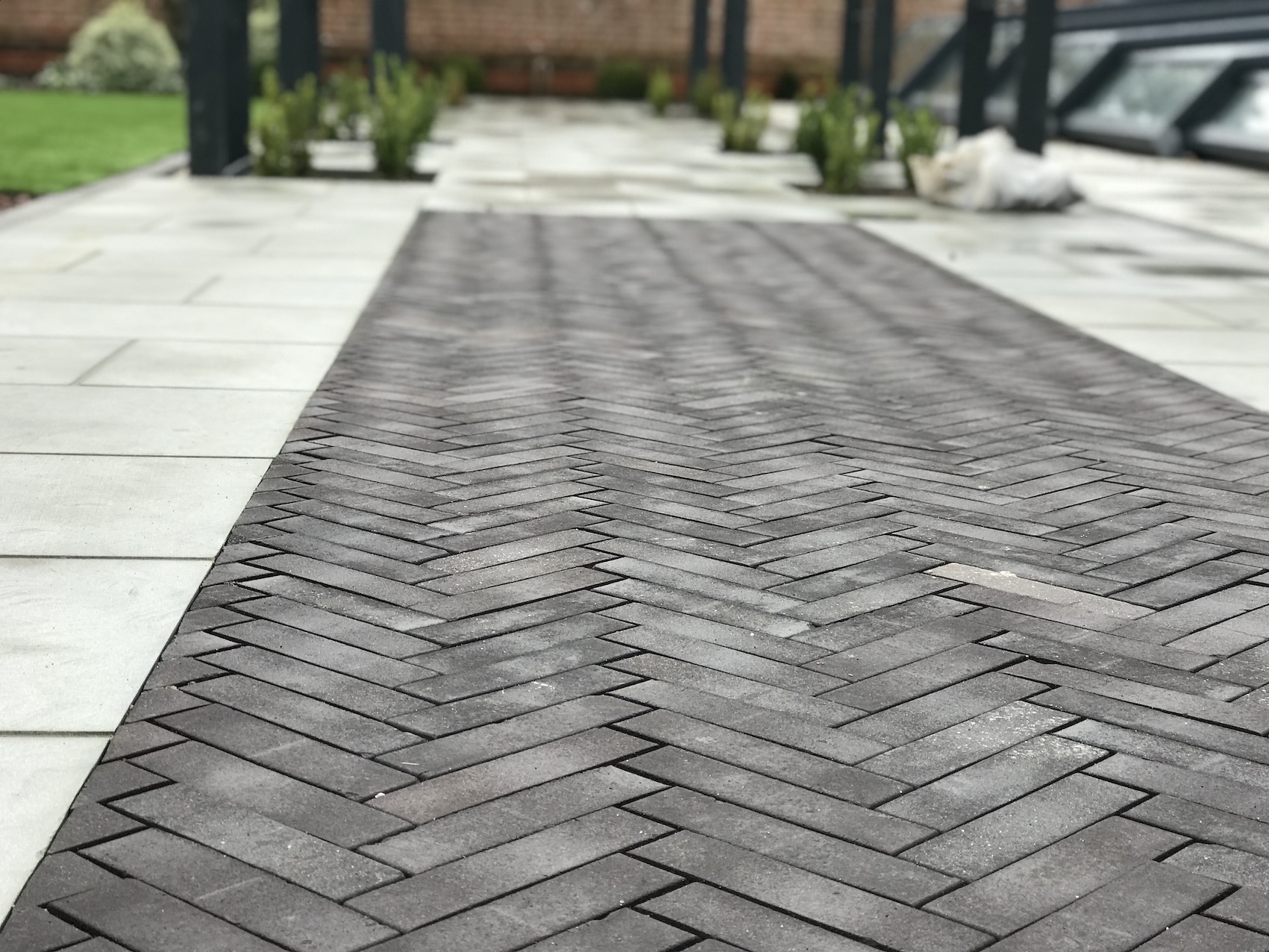 Dark herringbone paving set between pale paving